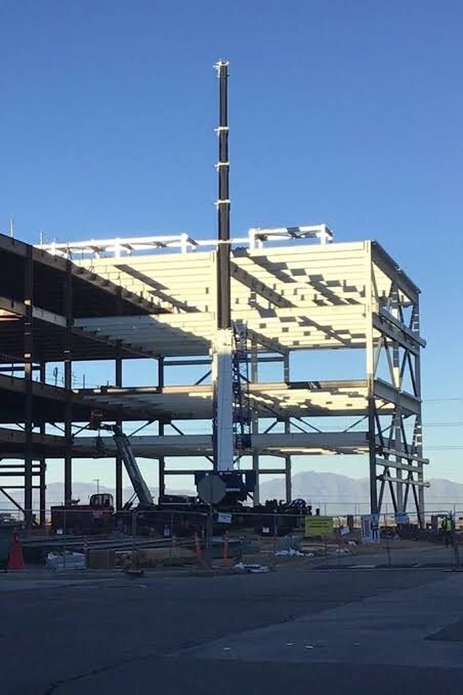 Multi-story structural steel frame being erected with a crane